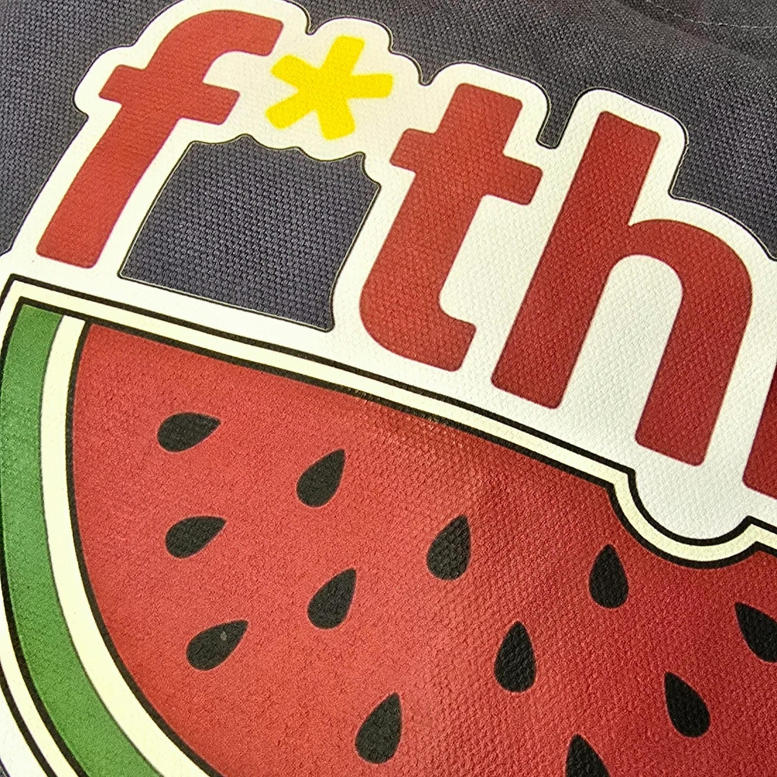 Sticker with watermelon design and partially visible text on a dark background