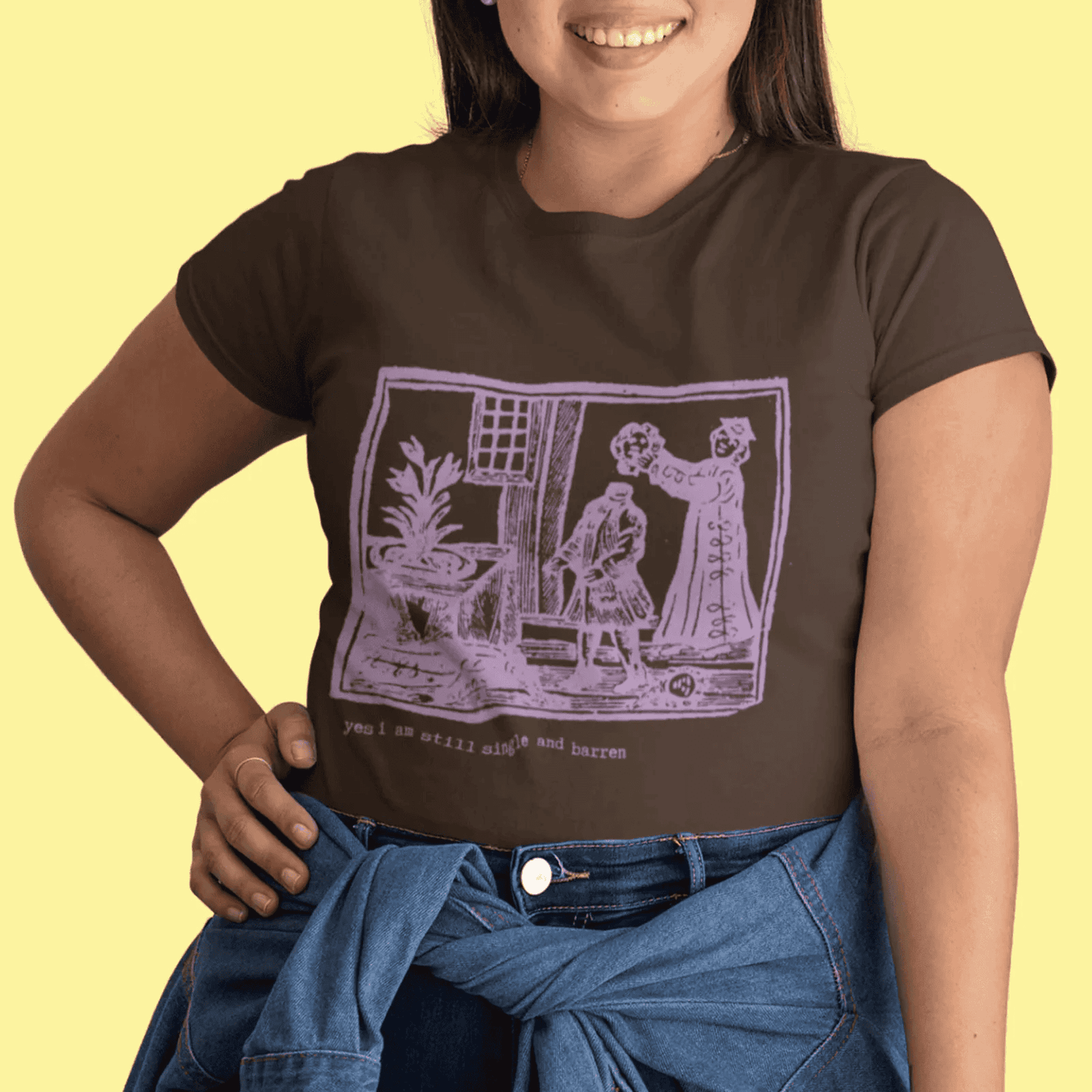 Person wearing a dark chocolate t-shirt with a graphic design saying "yes, I am still single and barren" on a yellow backgrou