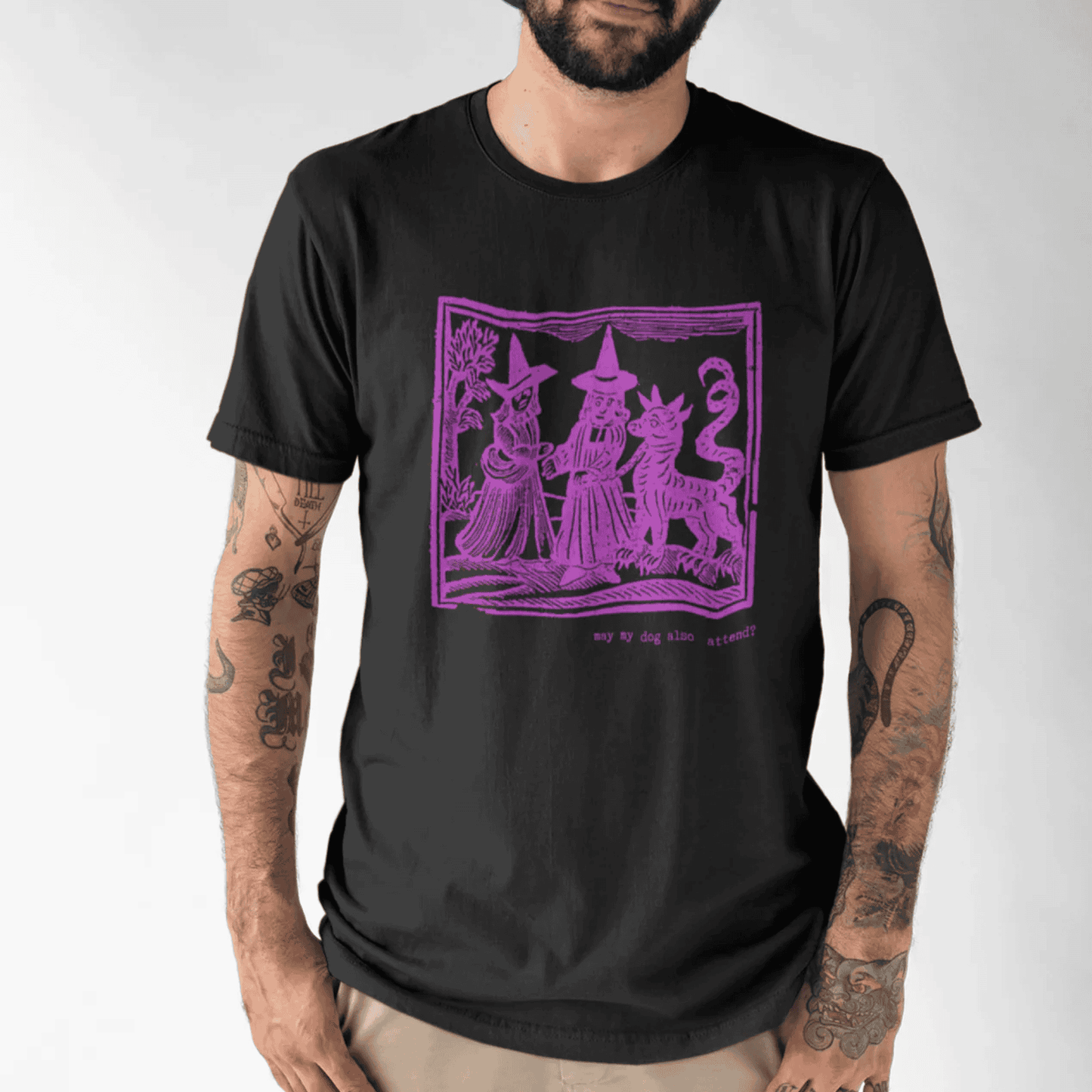 May my dog also attend? - man in black staple t-shirt with medieval woodcut style illustration of witches with a demon-dog - 