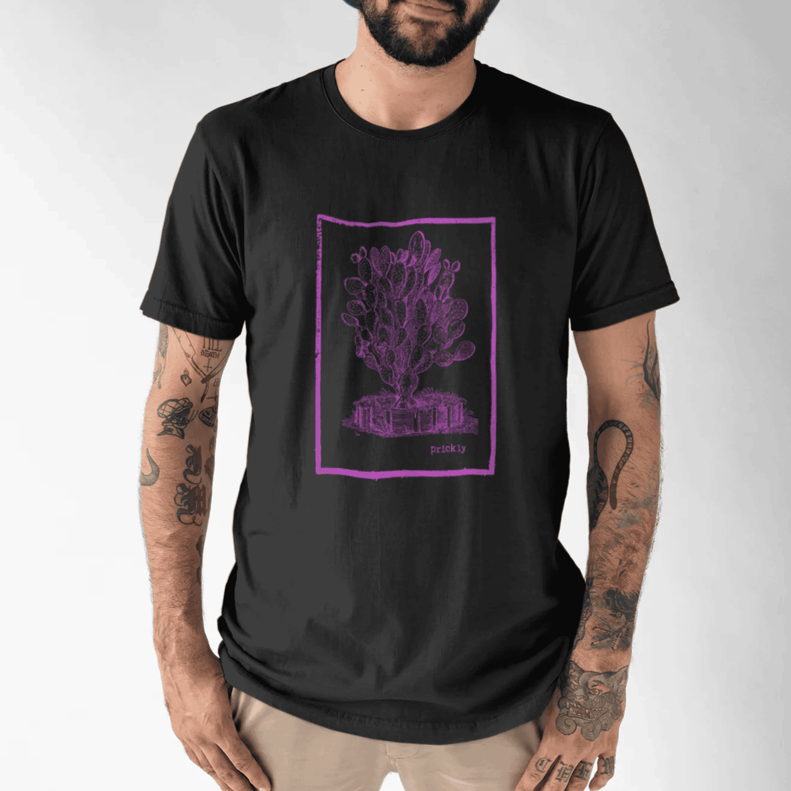 Man wearing a black t-shirt with a hot pink prickly design tee graphic design on a white background.
