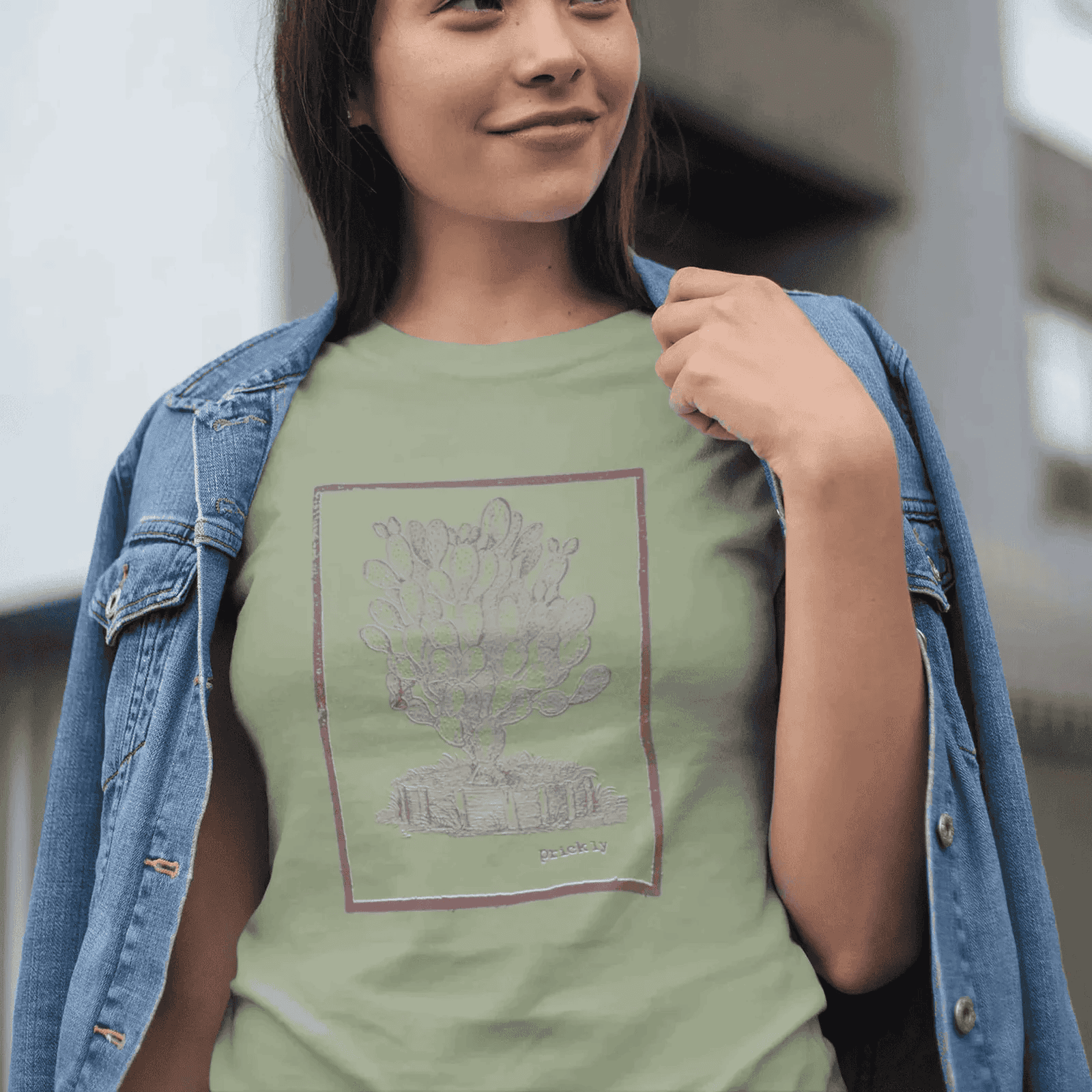 Woman wearing sage staple t-shirt with prickly design, standing outdoors