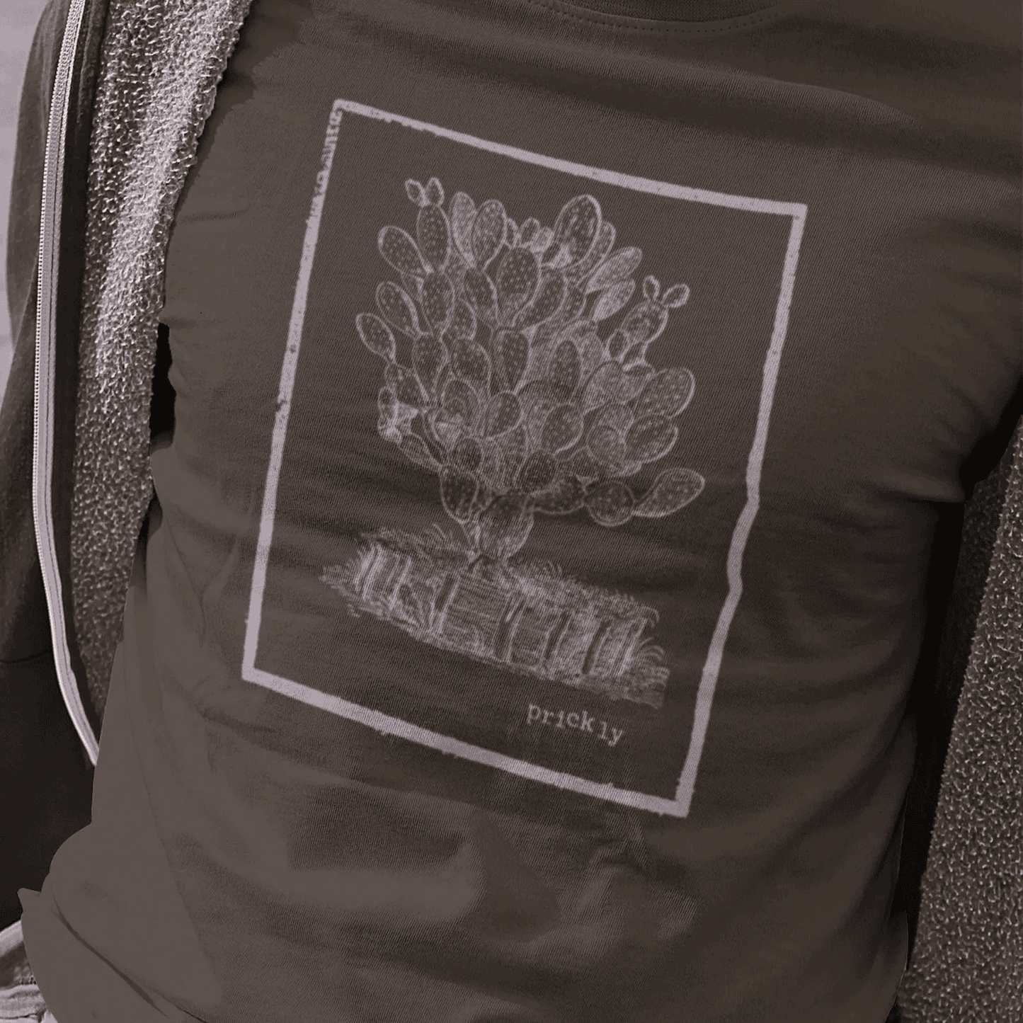 Man wearing dark chocolate staple tee with prickly design.