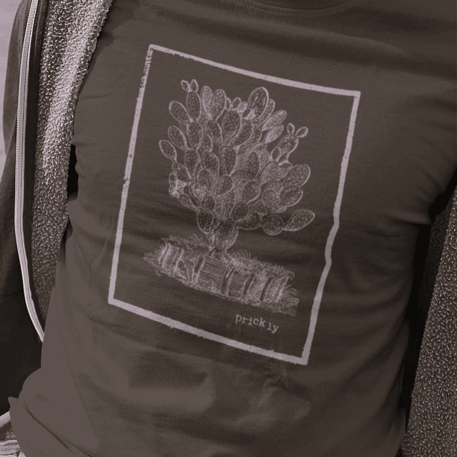 Man wearing dark chocolate staple tee with prickly design.