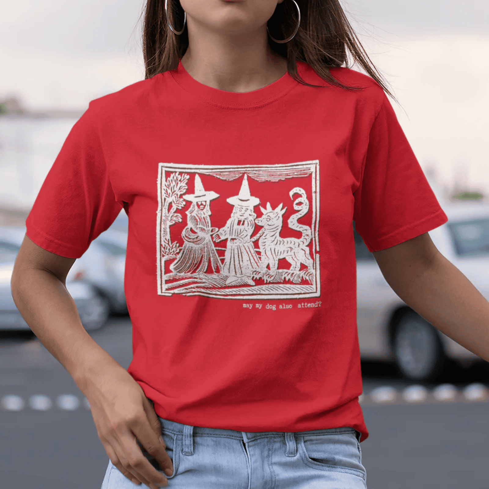 May my dog also attend? - woman in red staple t-shirt with medieval woodcut style illustration of witches with a demon-dog - 